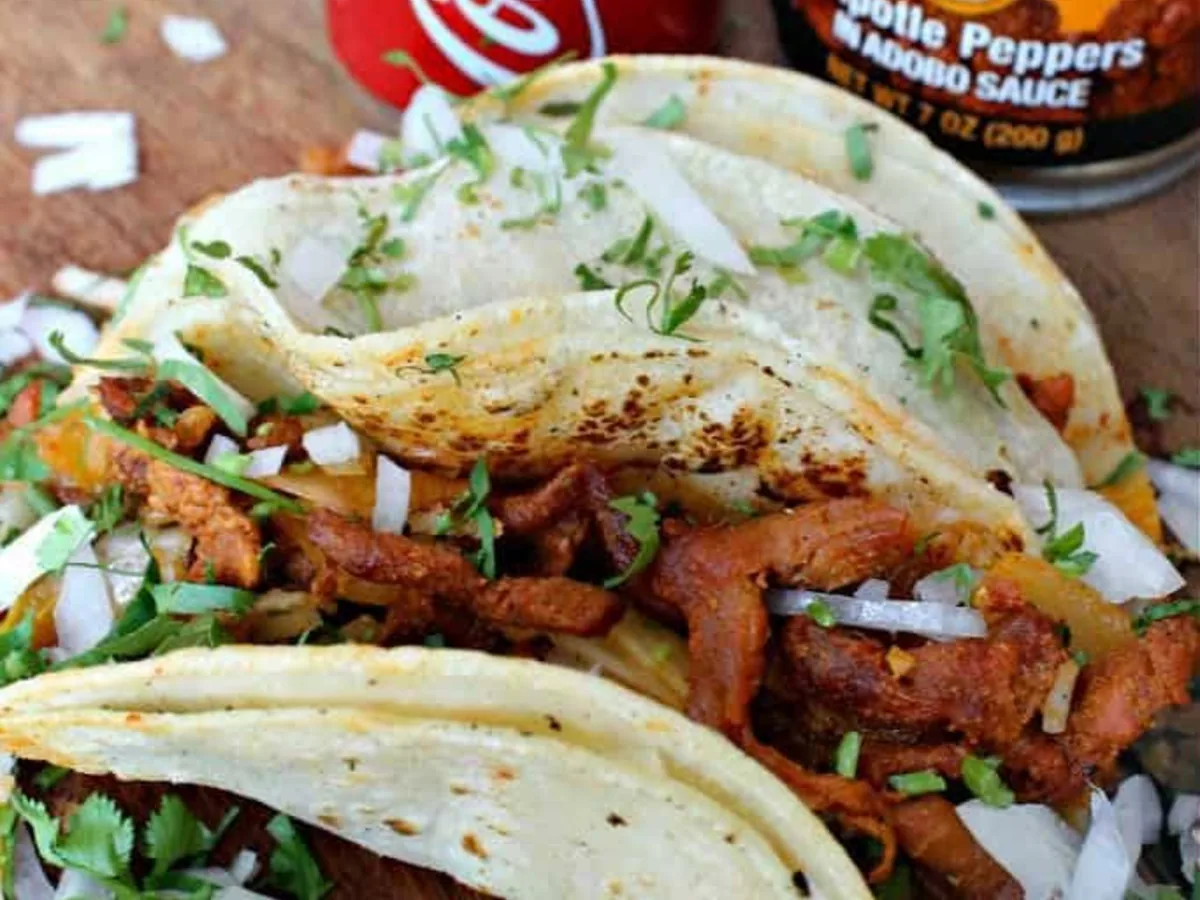 Tacos al pastor topped with diced onion and cilantro