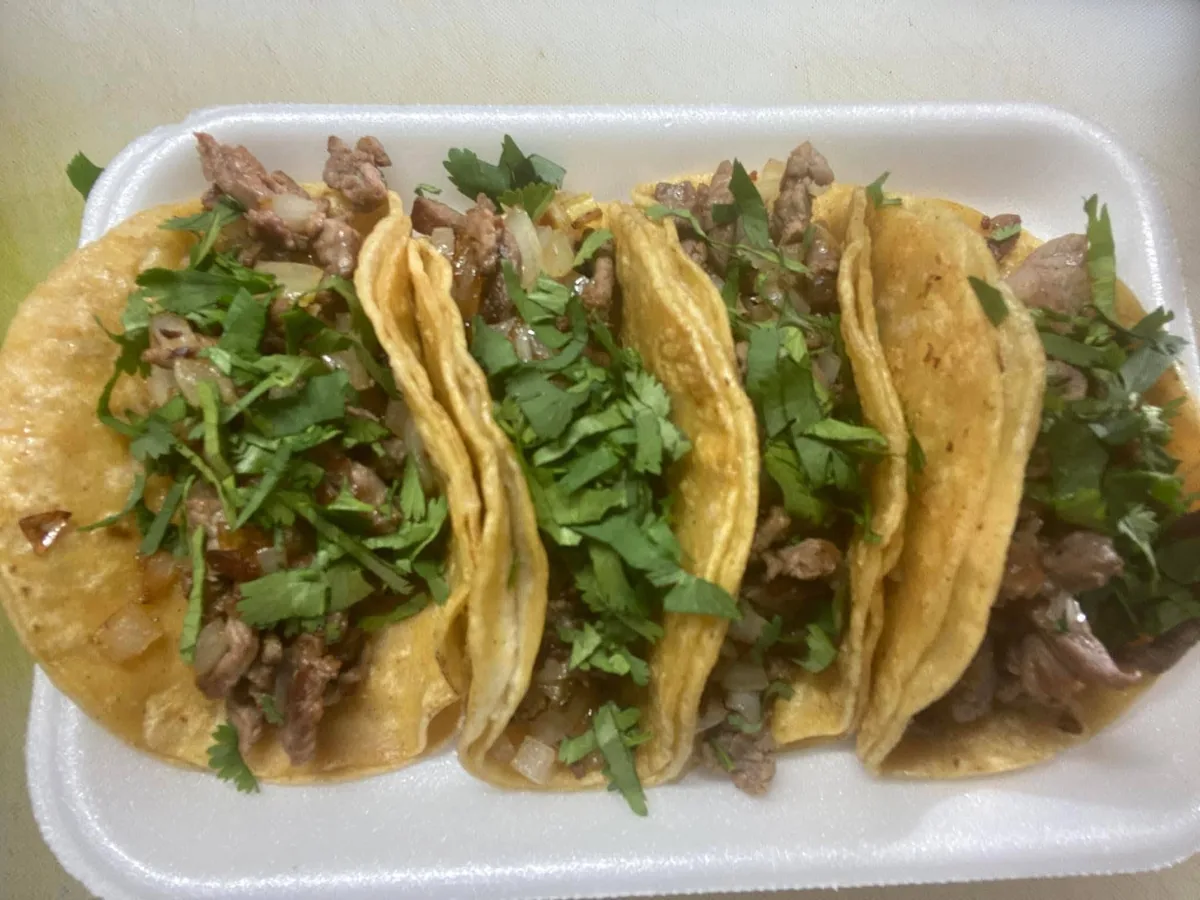 Tacos de carne asada with onion and cilantro in a takeout container