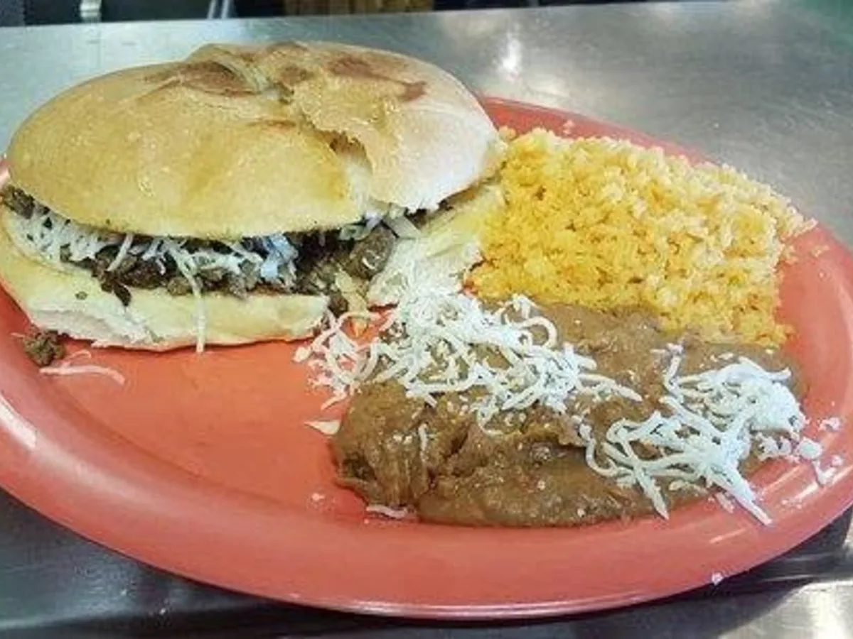 Torta de asada plated with rice and refried beans
